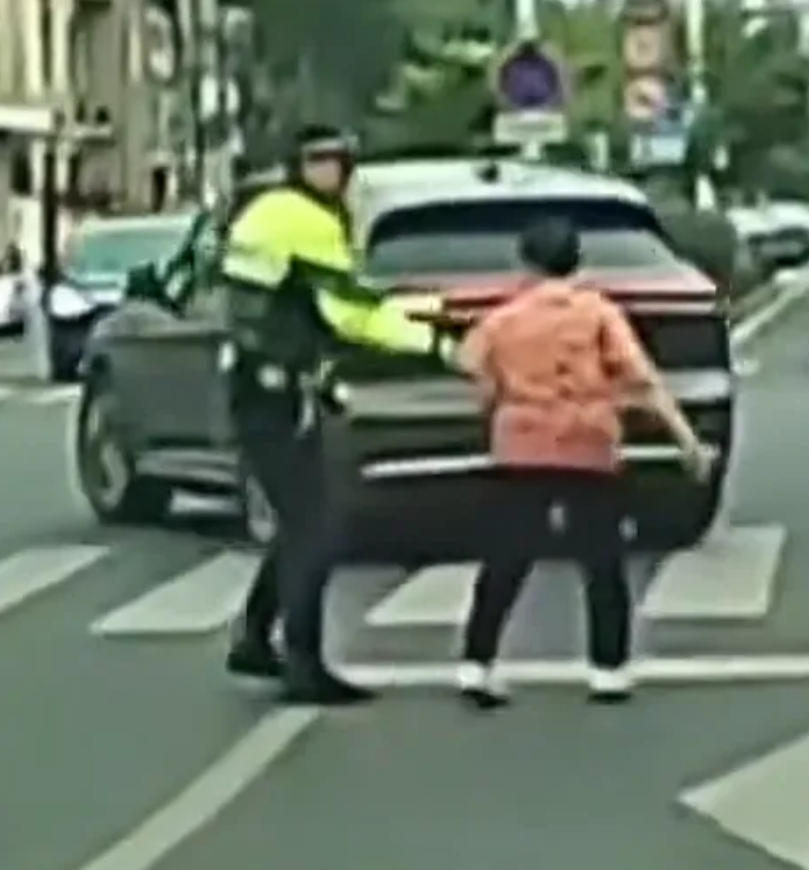 大妈闯红灯过马路太任性！红灯时不顾车来车往径直穿行，交警上前制止，她却甩开手执意