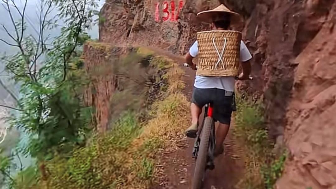 云南男子悬崖峭壁栈道上骑行 现场画面令人胆战心惊