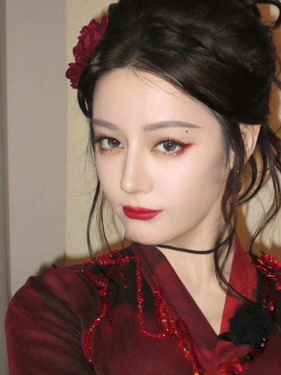 红纱裹身、鬓边簪花
端青花瓷杯时
眉眼藏着水墨江湖的侠气
像能仗剑走天涯的飒爽姐