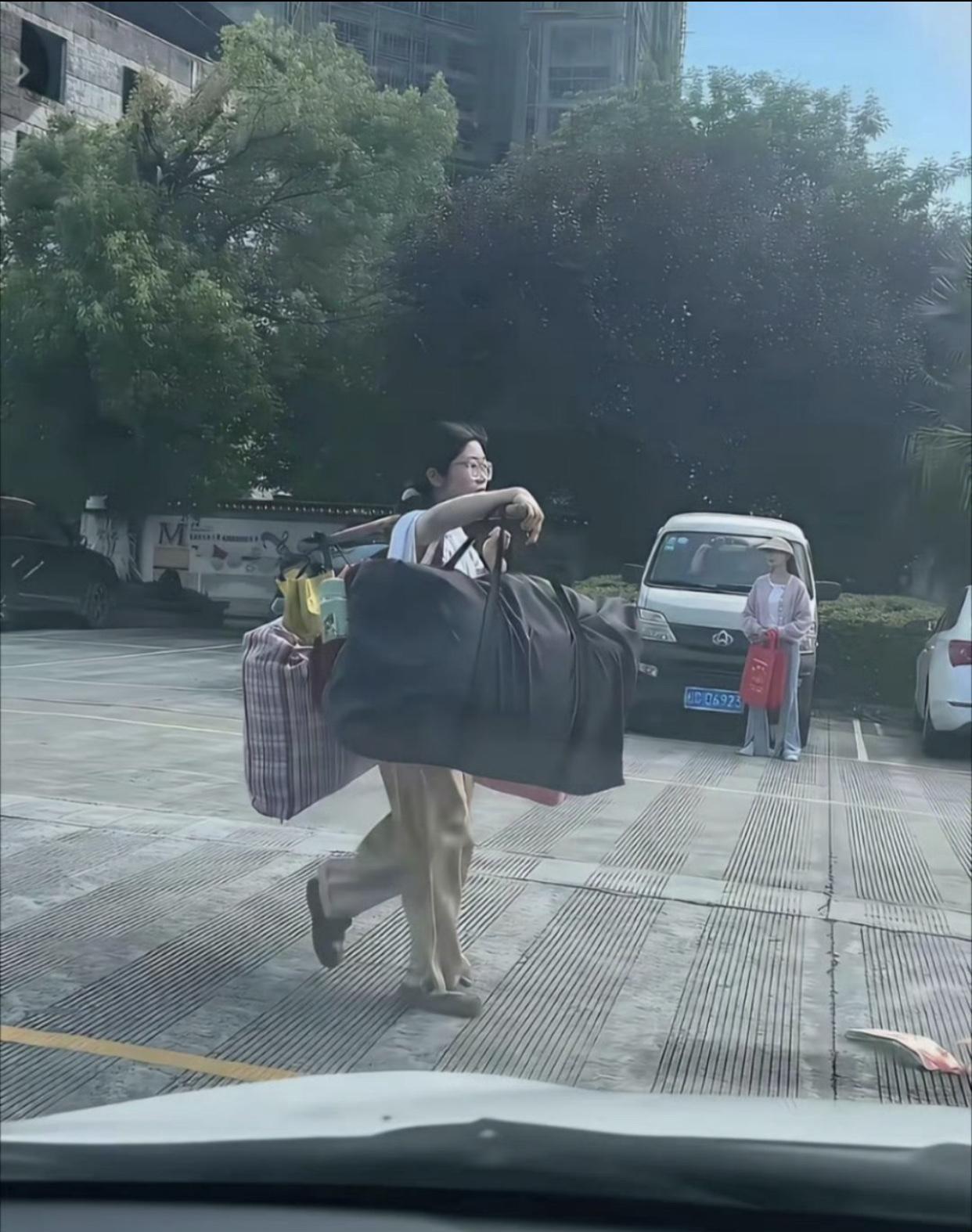 高考结束后，大多数学生都有家长或亲戚来接送并帮忙拿行李回家，但却有一位高三女生自