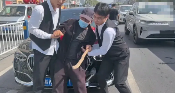 婚车开在路上正等红绿灯时，突然窜出来一个老头，年龄不小，腿还有点跛脚，拄着拐杖，