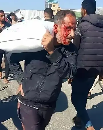 加沙，一个巴勒斯坦男人，为自己的家人抢到了一袋粮食。
