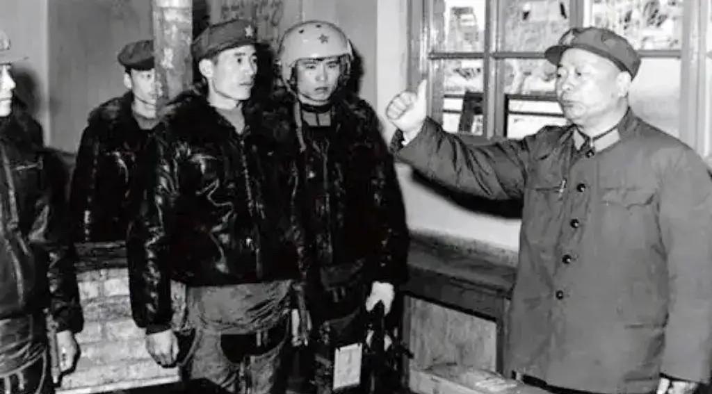 1980年，时任空军司令员张廷发将军（右一）赴西北某机场看望飞行员的场景。当时正