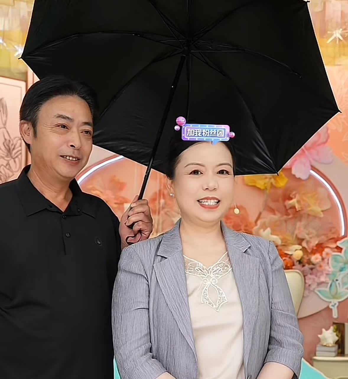 姚爸贴心为许妈撑伞。许妈妆容精致，一身浅灰色条纹西装搭配简约内搭，尽显优雅干练；