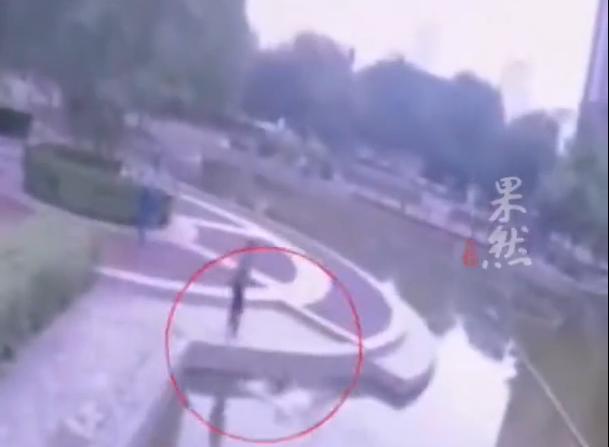 河北，一名十来岁小孩，站在自家小区景观池旁边玩耍，这个时候，后面悄悄靠近了一名同