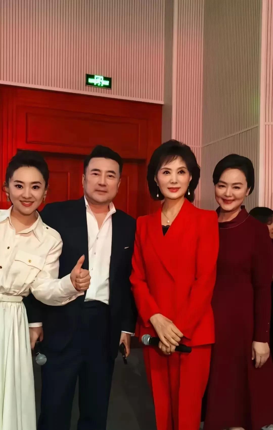 照片中左边是央视主持人月亮姐姐王昊，右边是央视主持人孙小梅，中间穿蓝色西服白色衬