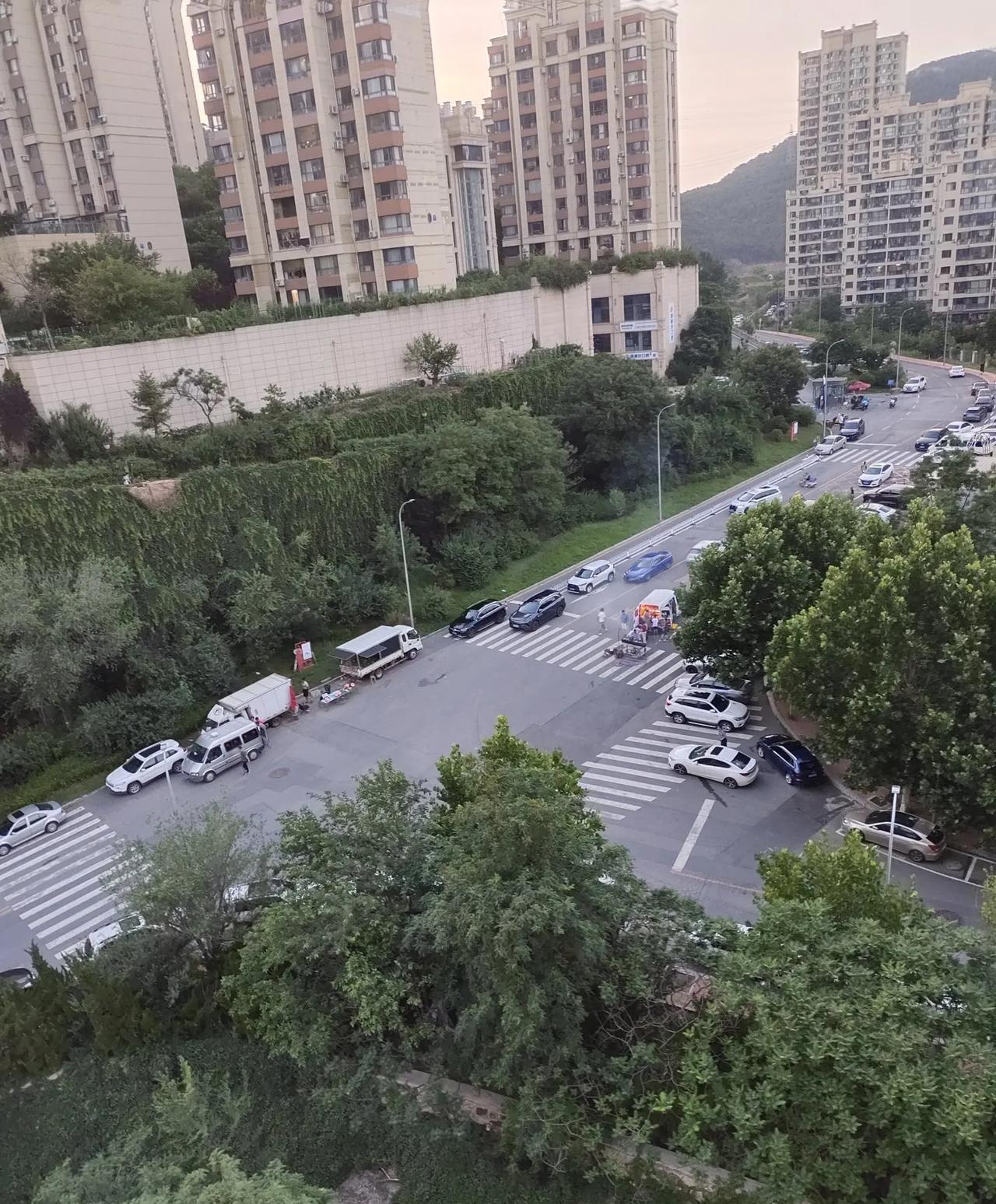 大连，高新区这一路口，经常有些小贩占道卖西瓜、烧烤，斑马线也被几辆小汽车停在在那