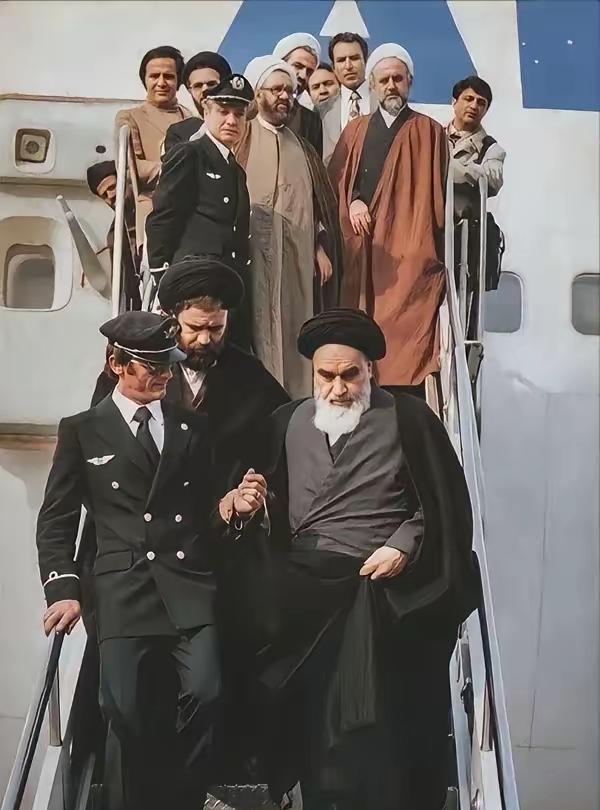 这是1979年法国航空将霍梅尼送往伊朗的照片，照片中霍梅尼由一名乘务人员牵着走下