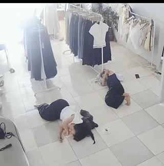 两名女子正躺在服装店里的地上午休，这时一只老鼠突然窜出来钻进了其中一名女子的裤腿