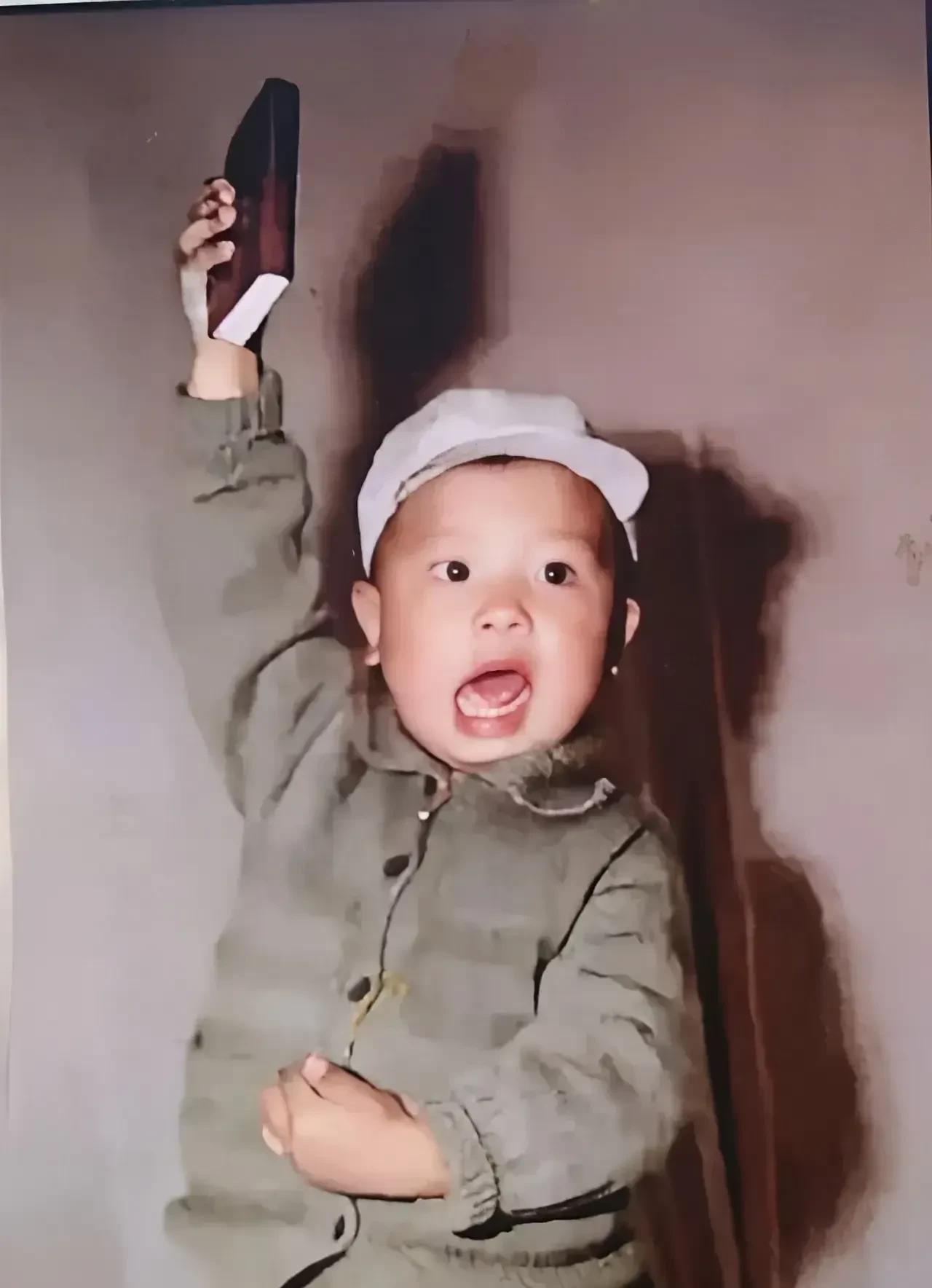 #迎端午粽香纳福#
这是上个世纪那个特殊年代才会出现的场景，画面里的小男孩高高举