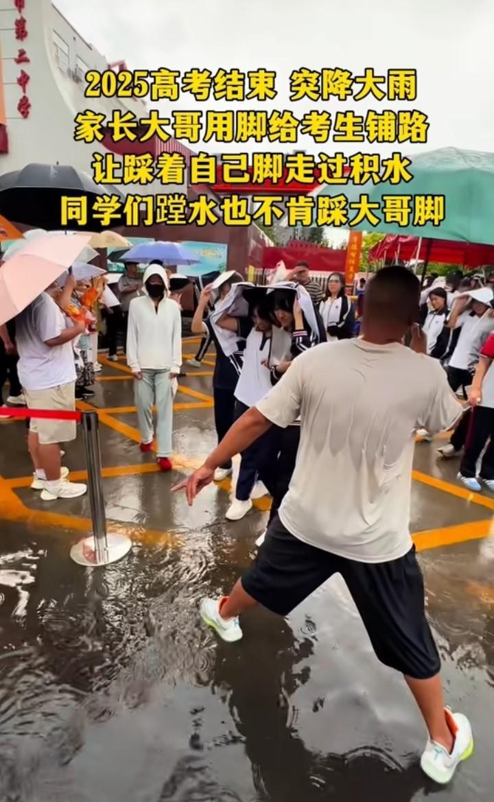 2025年高考后暴雨，家长用脚垫水坑，学生拒绝踩踏。



这场突如其来的大雨，