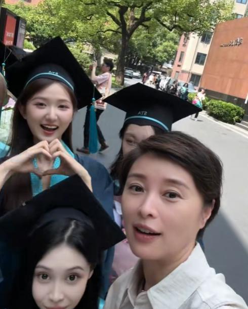 上海戏剧学院的学生正在校园里拍摄毕业证，吴越突然从后面走过来，学生们立刻兴奋得拉