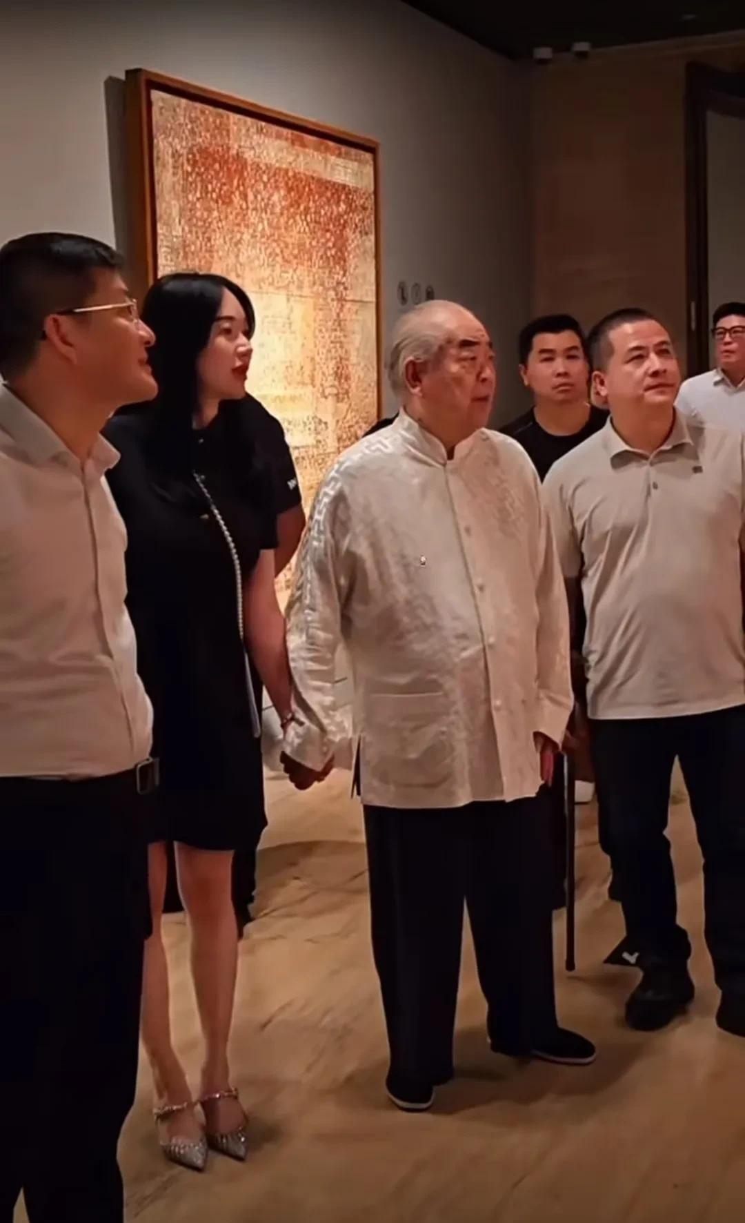 知名画家范曾带着小娇妻徐萌看画展，两人十指紧扣，看起来感情不错。
范曾已经88岁