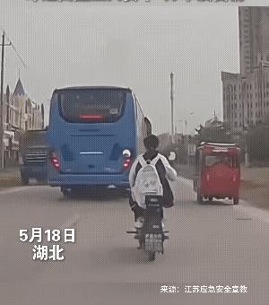 女孩骑电动车，距离前面的客车有些近，客车突然刹车，女孩慌张左躲，结果撞上了迎面来