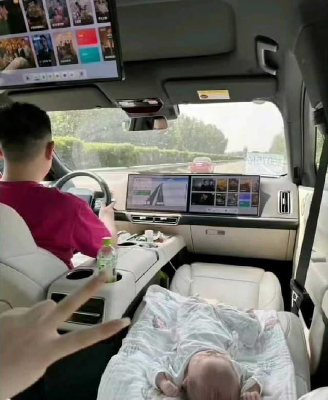 这样的危险行为还是不要做为好。
父亲前面开着车，母亲将孩子放在副驾驶上，孩子睡着