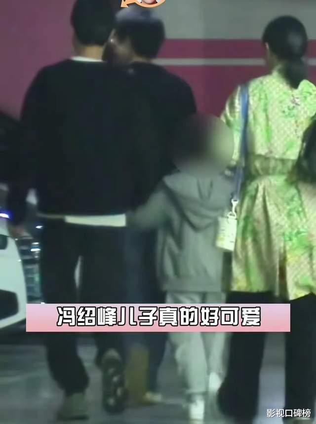 冯绍峰带儿子出门玩，想想随手扶起反光路障，父子俩手牵手很温馨