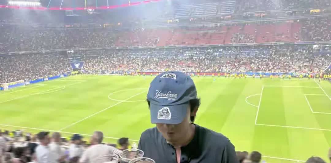 董子健看球赛，一身打扮不像有钱的星二代，单手端4杯饮料手劲大