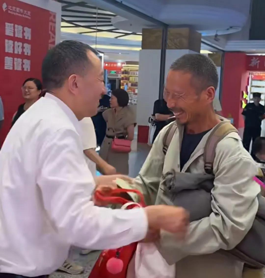 6月25日，西单读书大厦的签名售书活动里，作者陈行甲（左）将自己所写的书送给了一