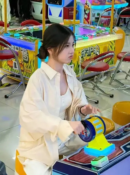 	虞书欣在电玩城里专心玩游戏，表情可爱。