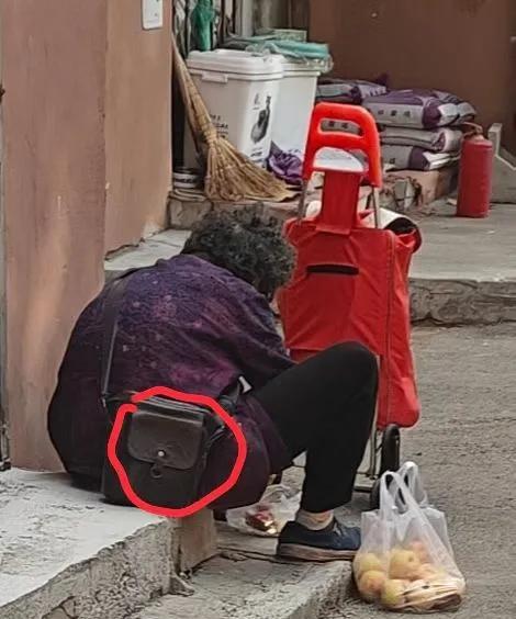 老大姐73岁了，花两块钱在司徒街早市上买了一塑料袋烂苹果，在用小刀削苹果腐烂的部