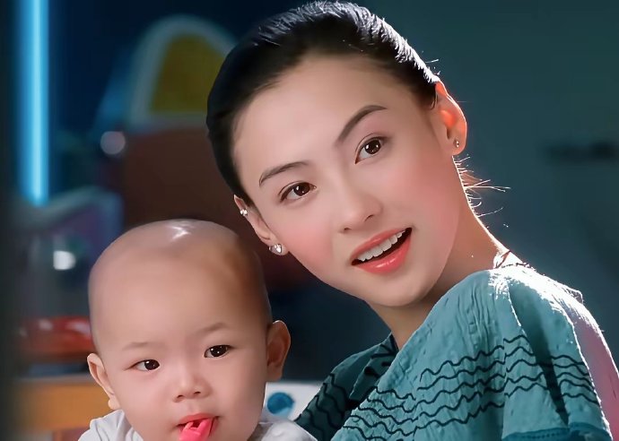 看她跟几个月大的婴儿同框，她们的头骨脸型居然差不多一般大 ​​​