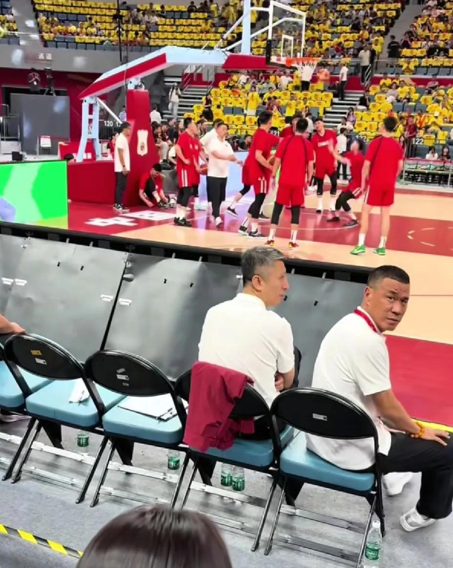 中国男篮正在热身，主教练郭士强坐在场边观看，这时郭士强身后不远处一个球迷朝他喊话