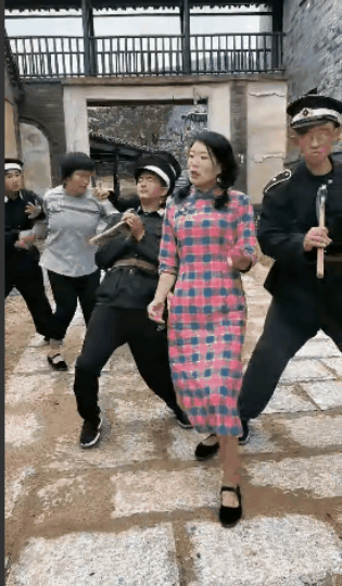一个地下女游击队员发现她的同事，被叛徒告密了，被伪军抓了起来，伪军 压着被抓的游