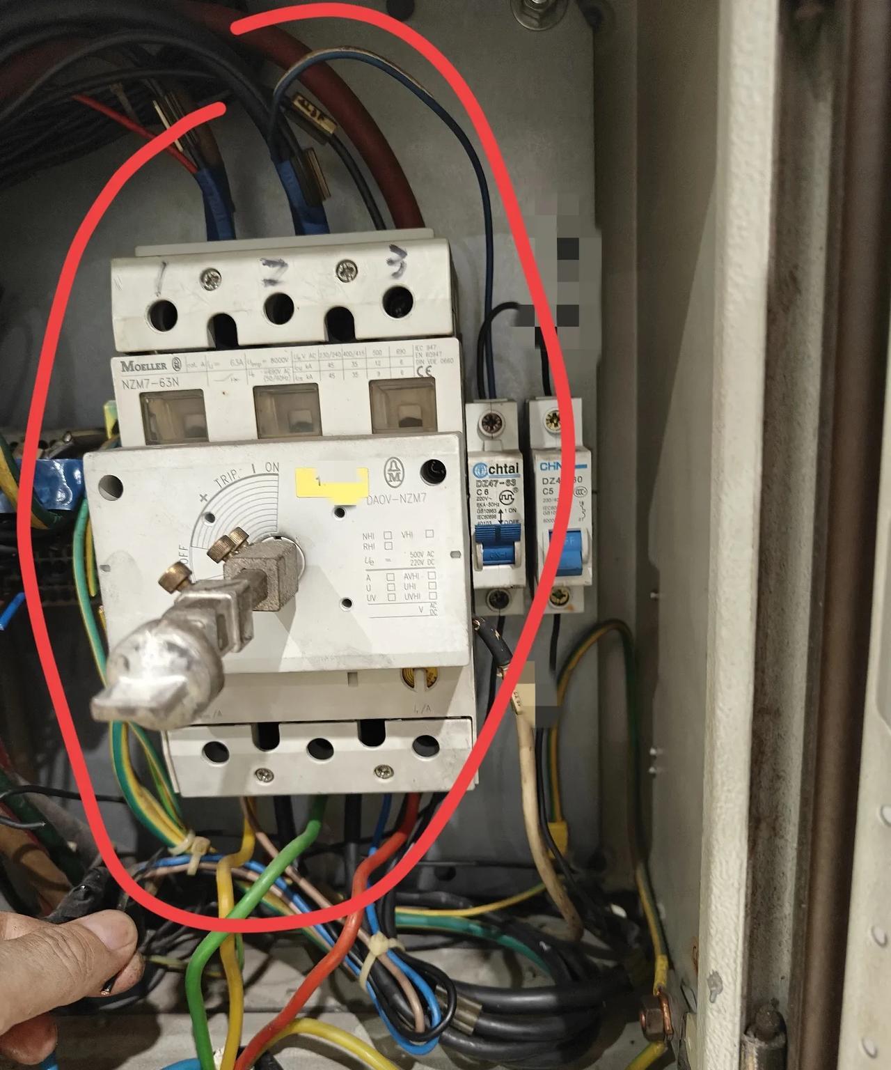 厂里的电工杨师傅带着新入职的电工在车间里熟悉工作环境。新来的电工看到电箱里有一个