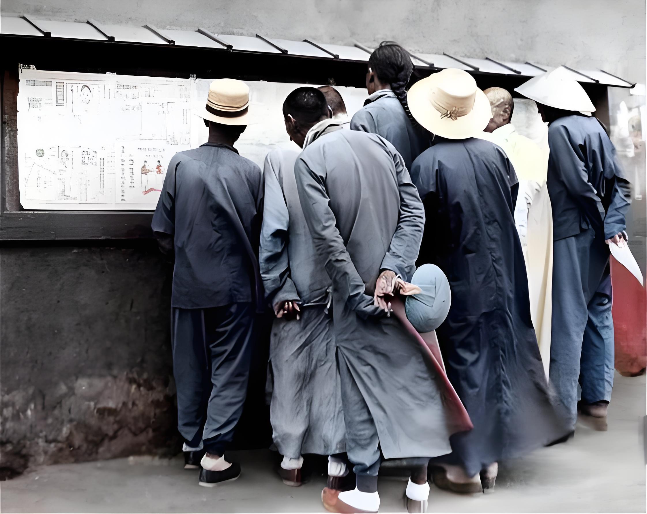 这张照片展示了1911年上海人们看报纸的场景，内中一人还留有发辫。