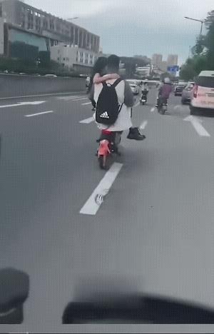 他不仅没戴头盔，而且还怀抱一个女子骑着电动车，招摇过市。
这样骑电动车也不安全呀