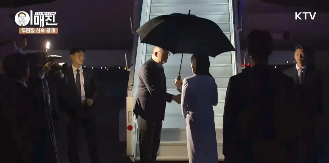 李在明结束G7峰会后，深夜乘坐专机回国。
当天夜里下着大雨，李在明从车里出来后接