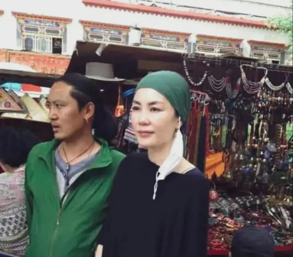 王菲西藏祈福，绿巾黑袍显素净，温和神态慈眉善目。肌肤依旧白皙、胳膊纤细，只是岁月