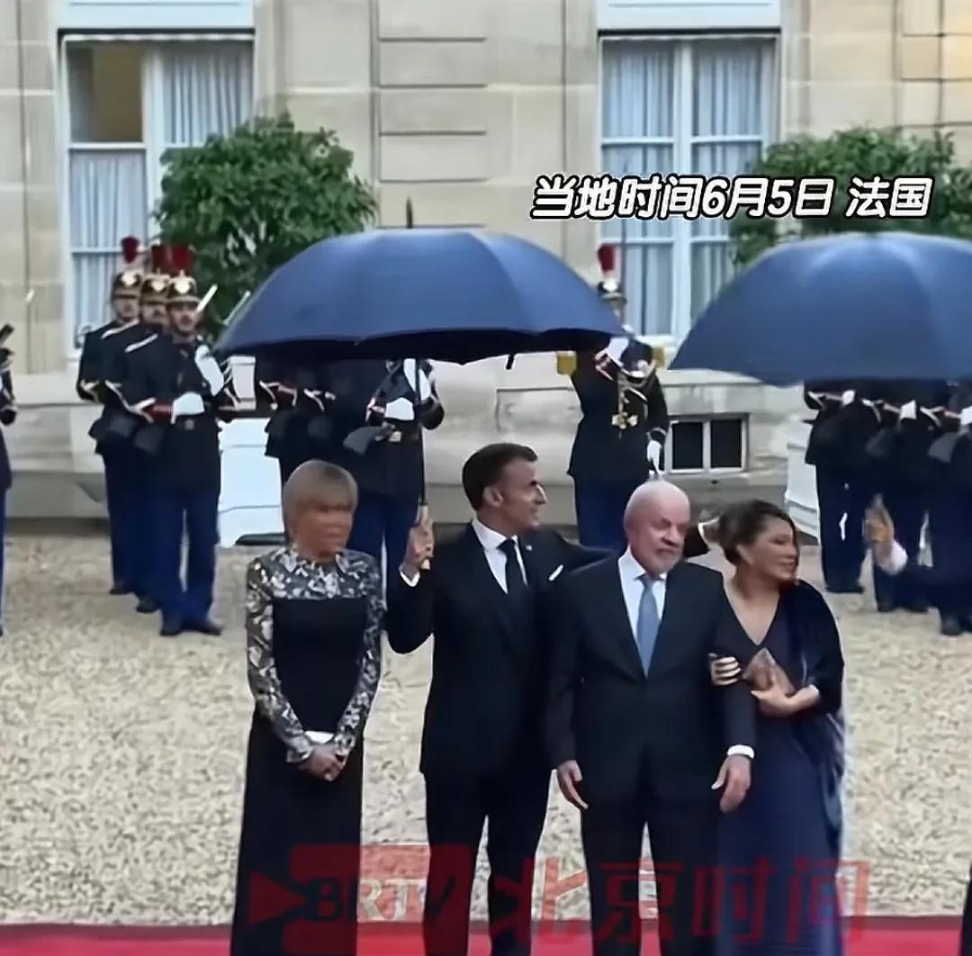 巴西总统访问法国，马克龙一个人淋了两份雨。
在爱丽舍宫广场迎接的时候正直下雨，红