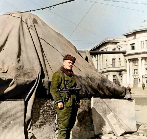 1946年，辽宁沈阳街头，一名苏军士兵站在被帆布覆盖的坦克旁边，一副耀武扬威的样