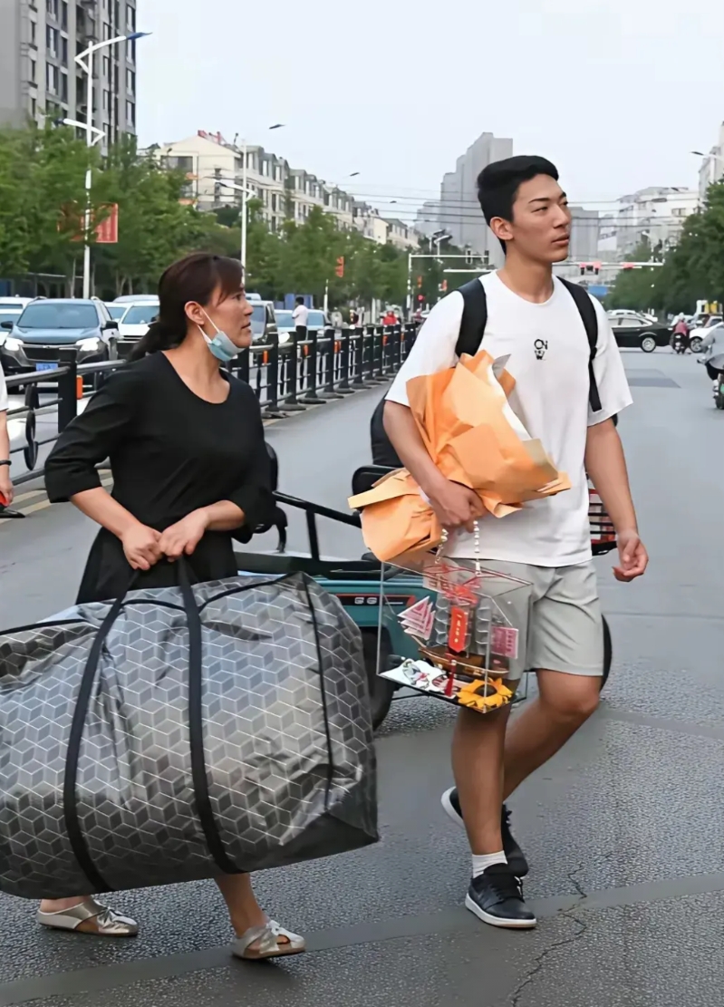 两张高考生有趣的对此图。第一张，男生考完试后，手里拿着妈妈送的一束花和一件纪念品