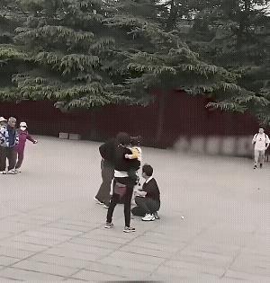 一对情侣在公共场所说话声音大了，黑衣男子认为吓着了他的孩子，上去就把男生绊倒了，