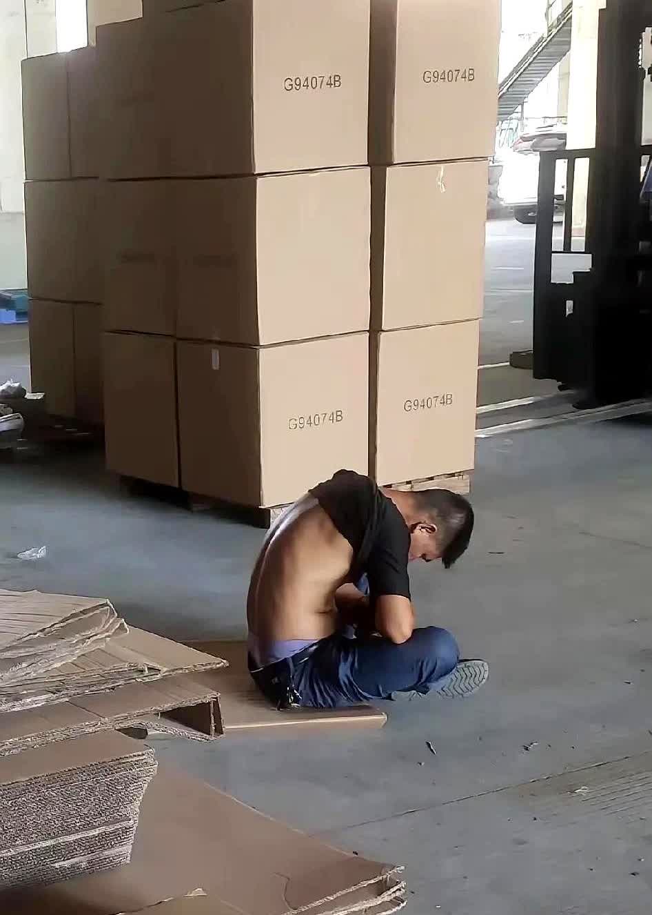 广东东莞有一名男子下午上班看到一名从外地前来厂区送货的司机坐在地上的纸皮上睡着了