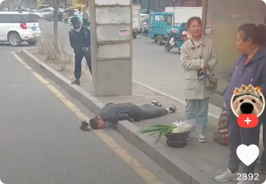 年轻女子在等公交车时，突然晕倒，倒在地上，没有一个人敢扶，甚至没人帮打120，也