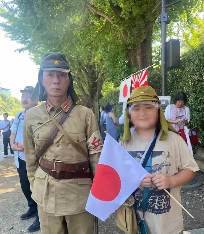 这父子二人，身着二战时期日寇的军装，参拜靖国神社，神气活现的摆拍。
这场景，凸显