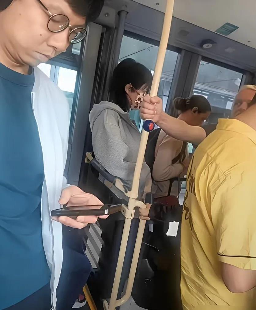 55岁的王菲在异国他乡体验公共交通，身穿休闲卫衣，一头利落短发，酷劲十足。她选择