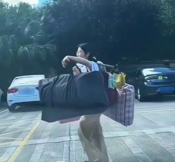 一担行李，全网破防！广西，一女生高考结束后，用一根木棍挑起塞爆的两大包行李，步伐