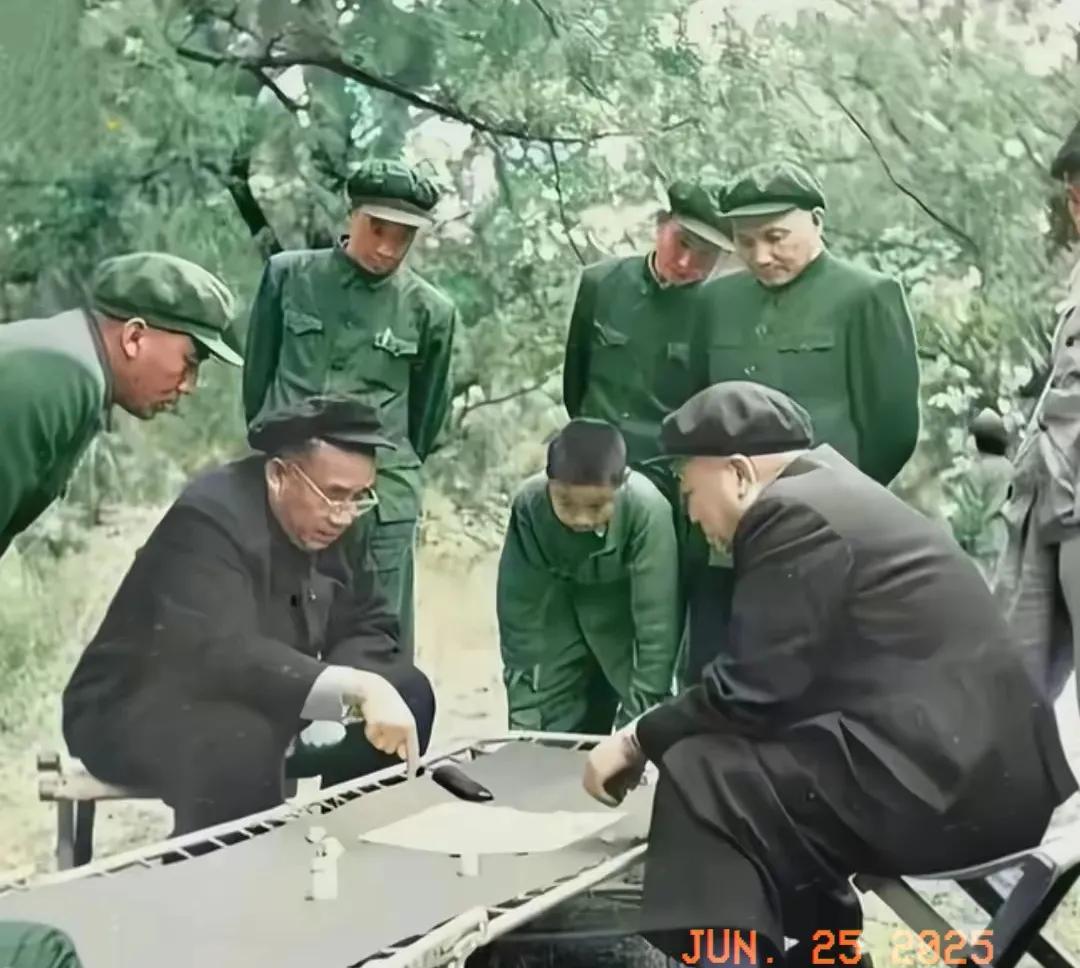 历史故事分享。
朱老师与彭老总正在切磋棋艺，周围很多旗友正在围观，条件艰苦，折叠