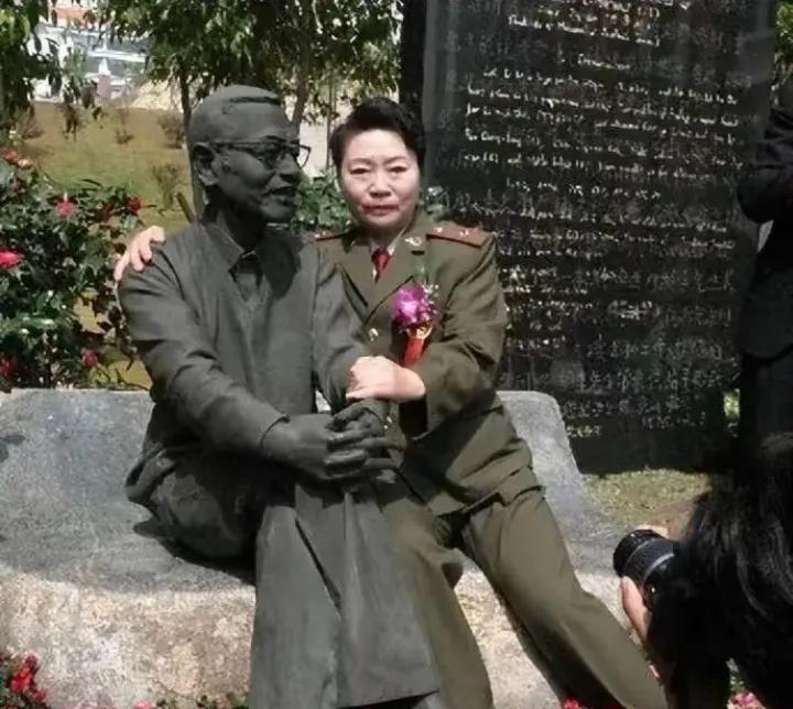 1997年，陈景润的夫人坐在丈夫的雕塑旁边，搂住“丈夫”的肩膀，留下了这张令人垂