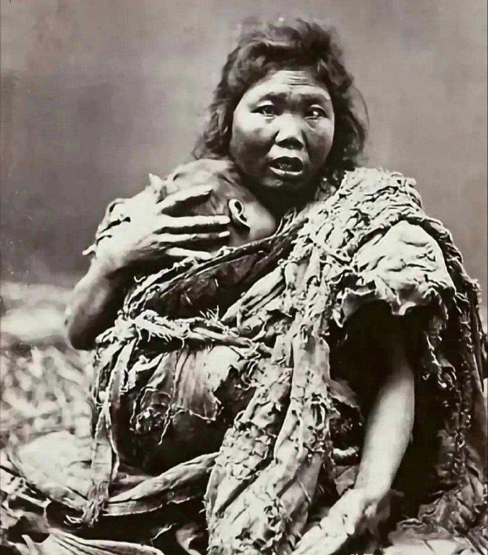 晚清时期，大街上一对饥寒交迫的母子在行乞。

衣不蔽体的母亲裹着一条烂棉被，怀里