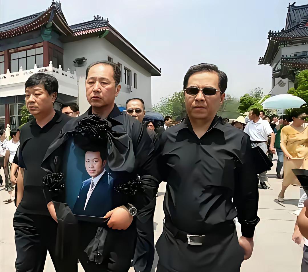 2009年，中央电视台著名主持人罗京48岁去世，他的家人怀抱罗京的照片大步前走。