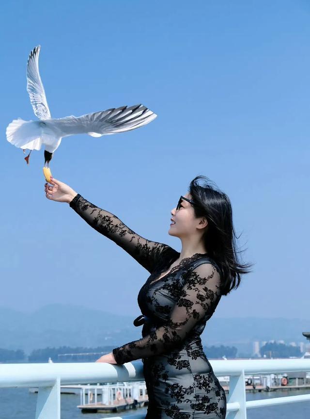 蓝空似海映娇姿，玉手轻伸呈美味。
