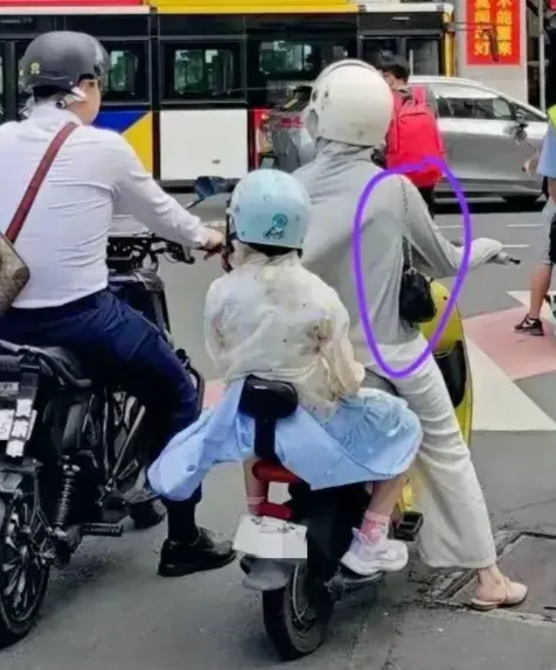视频中的场景，是一位驾驶电动车在路上行驶的老年妇女，竟然违反交通规则闯红灯，这是