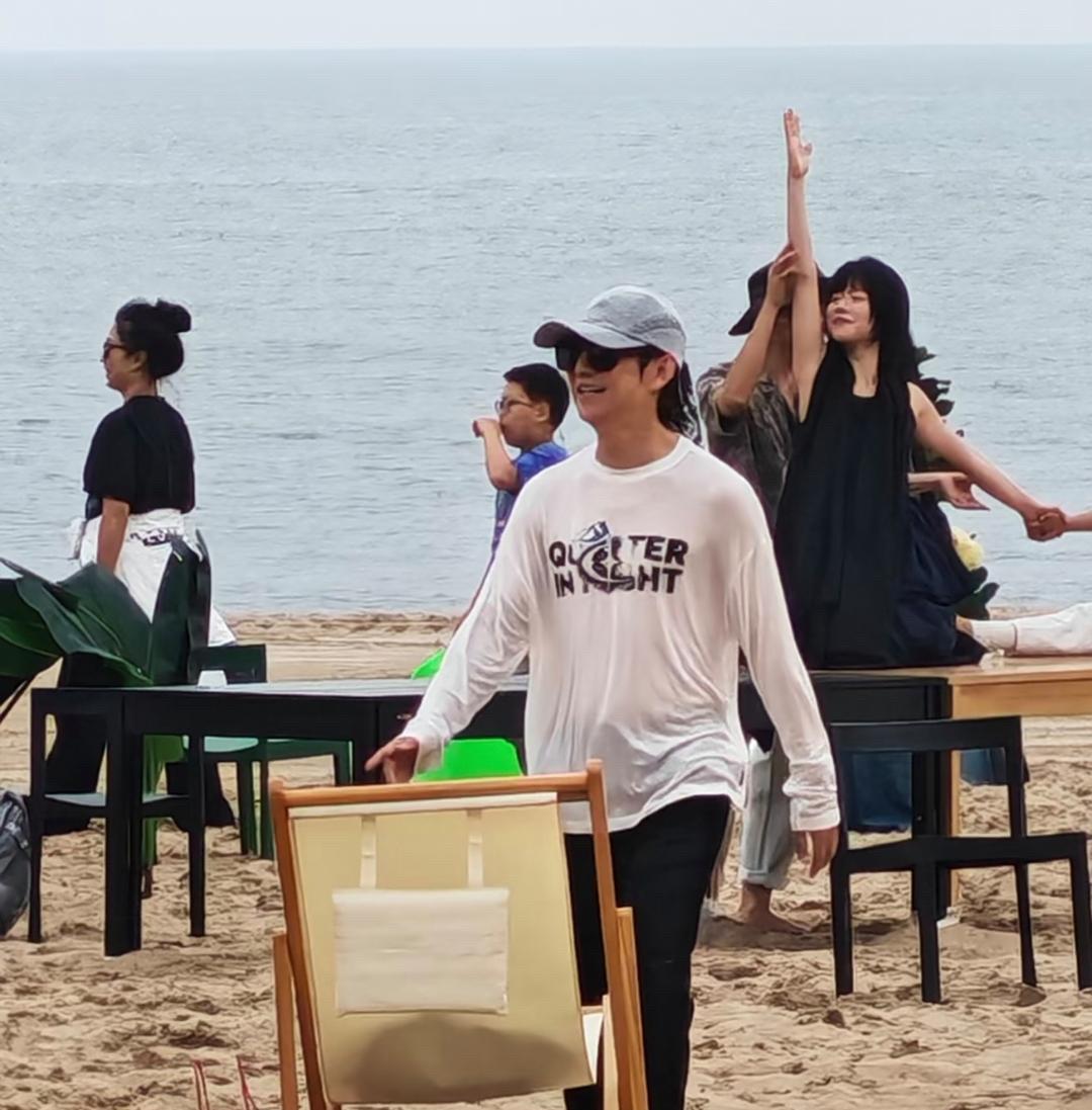 51岁何炅在阿那亚海边度假，他赤脚在沙滩上玩，看起来好开心。他的个子很矮，目测1