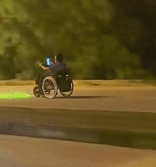 一名男子在凌晨的街头，乘坐电动轮椅在马路上狂飚！
看起来他的车速非常快，简直和摩