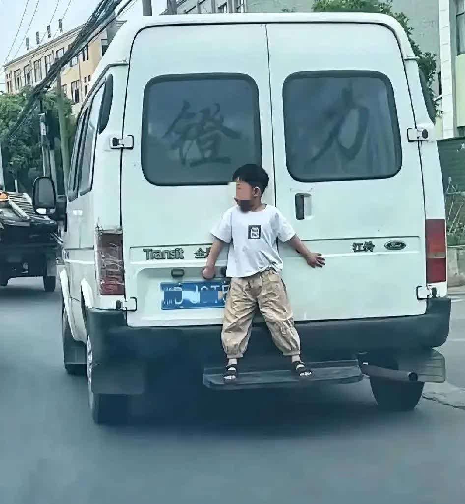 小孩站在车尾踏板上，真的太危险了！有个四五岁男孩站在江铃金顺后面踏板，双手摸着车